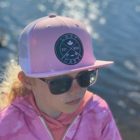 Youth wearing pink trucker hat with crossed rods lastcast design